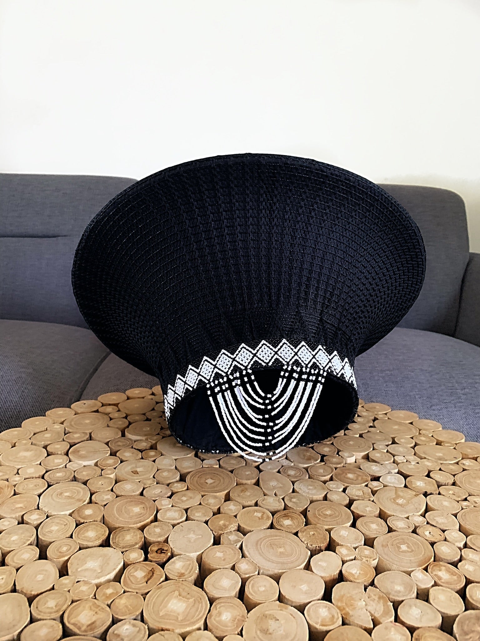 Black hat with white tassels and U-shaped tassels